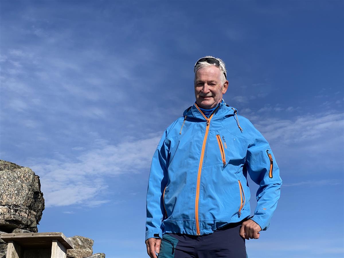 Foto av mann i blå jakke og blå himmel i bakgrunn - Klikk for stort bilde
